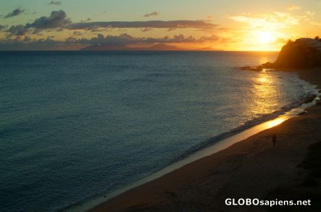 Postcard Antiguan sunset with a beach & cliff