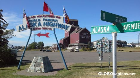 Postcard Munument marking beginning of Alaska Highway