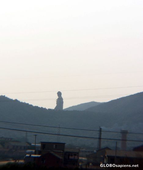 Postcard Buddha looming over the houses and the hills