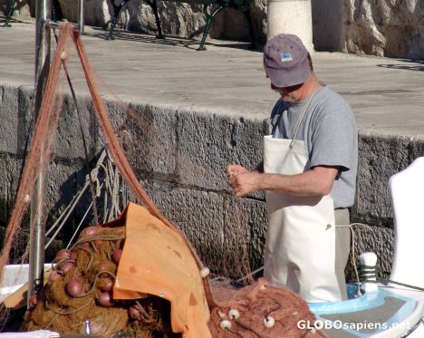Postcard Fisherman mends his nets in Dubrovnik harbour