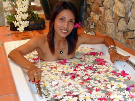 Postcard Thai lady taking a bath with tropical flowers.