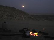 Campfire under a full desert moon