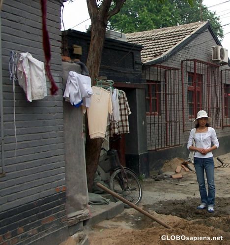 Postcard Woman standing in one of the hutong streets
