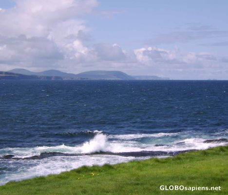 Postcard A wave breaks with the Céide fields beyond