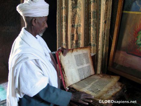 Postcard Monk and a 800 years old book.