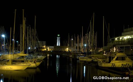 Postcard Lighthouse of Trieste with some boats moored.