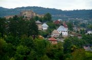 The view of the old Jajce with the fortress on the hill and a couple of houses in traditional style.