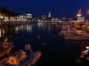 Split's fishing harbour at night, a couple of ferries leave from the same waterfront.