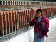 Woman spinning prayers wheels at Changangka Dzong