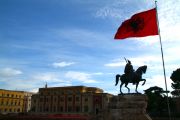 Albanian flag flying by the side of the monument of the Albanian hero, Skanderbeg.